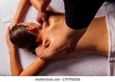 Masseur Hands Doing Back Massage To Client In Spa Center In Dark Room