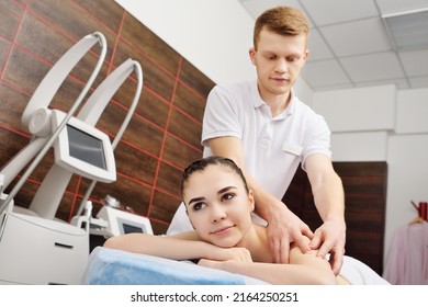 Masseur Man Doing Shoulder Girdle Massage To Attractive Young Woman