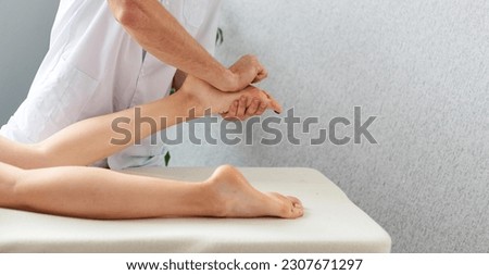 The masseur massages the feet of the woman lying on the massage table. Massage therapy the medical center.