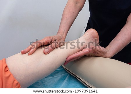 The masseur performs a foot massage. With his own hands, he massages the foot of the foot.