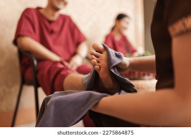 Masseur washing feet of customer and wipe the water with a towel in spa salon. Relaxation foot massage. Selective focus. - Powered by Shutterstock