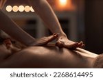 Masseuse applying hard pressure into sore muscles of female client