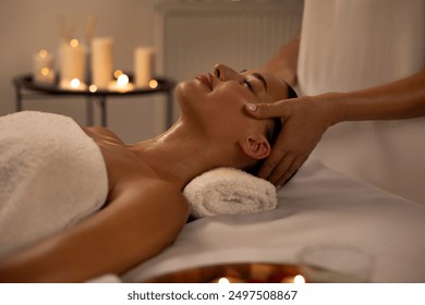 Masseuse making relaxing head massage for young lady, peaceful woman getting healing head massage at modern luxury spa in romantic atmosphere - Powered by Shutterstock