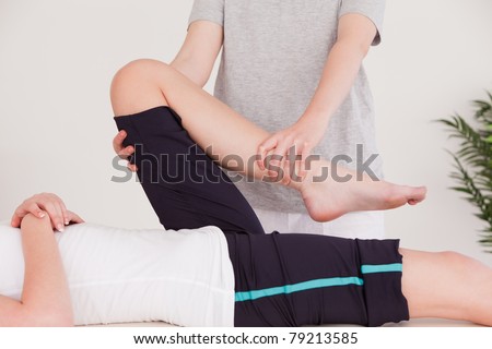 Masseuse stretching the leg of a young woman