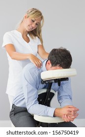 Masseuse Treating Clients Neck In Massage Chair In Bright Room