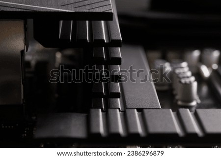 Massive black heatsink and Japanese capacitors on a modern personal computer motherboard. Passive cooling in a personal computer. Photo. Selective focus. Close-up