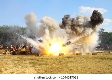 Massive Bomb Explosion During Re-enactment Of Medieval Battle. Blowing Up On The Battlefield With Flame And Clouds Of  White And Black Smoke. Detonation Of The Cannon Ball. Living History Festival. 