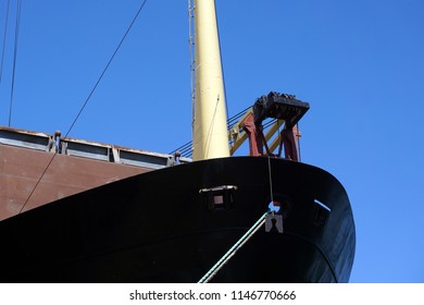  The massive bow of a large ship,  with crane, at the seaport                                   