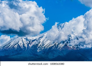Massive clouds floating across the snow peaks