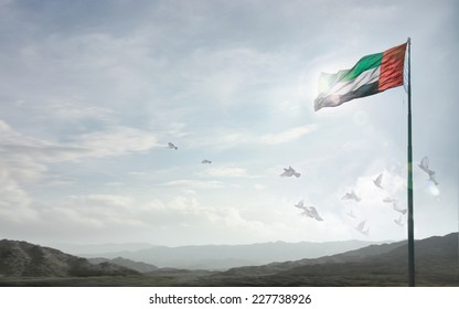 A massive flag of UAE flying against a horizon of Hajjar mountains, Fujeirah, UAE. - Powered by Shutterstock