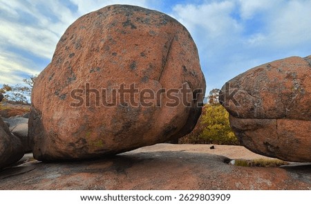 A massive granite boulder delicately balances atop bedrock at Elephant Rocks State Park, shaped by millions of years of weathering under open skies and changing seasons.