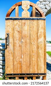 Massive handmade rough wooden door with metal handle close up