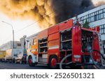 Massive large blaze fire in the city, blazing warehouse factory, storage building burning, firefighters team putting out the fire, firemen on duty, extinguish the fire, arson, burning house damage 