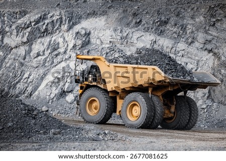 Massive Mining Dump Truck in Active Quarry with Rocky Terrain.