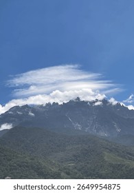 Massive mountain below the cloudy blue sky