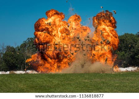 A massive orange fireball explosion with debris flying from the detonation site.