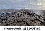 Massive river stream falling down hillside and edges in Icelandic region creating nordic Gullfoss waterfall. Fantastic wintry scenery with freezing cold water in arctic landscape running off cliffs.