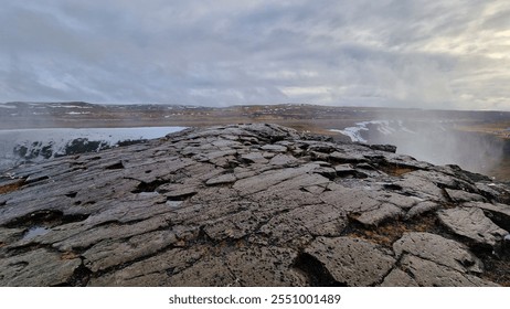 Massive river stream falling down hillside and edges in Icelandic region creating nordic Gullfoss waterfall. Fantastic wintry scenery with freezing cold water in arctic landscape running off cliffs.