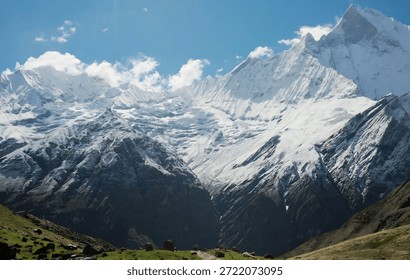 Massive Snow Capped Mountain Range Under Clear Blue Sky with Fluffy White Clouds