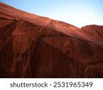 Massive solid stone wall overhang directly over the head in Buckskin Gulch canyon