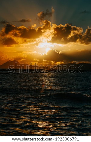 A massive sunset between the clouds with some islands over the ocean