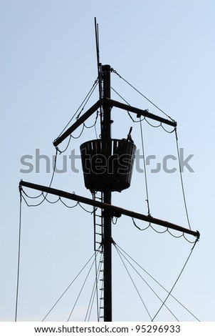 Mast of ancient pirate ship on the blue sky background
