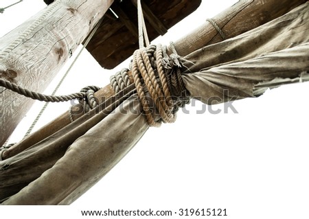 Mast of pirate ship with old sails tied rope isolated on white background