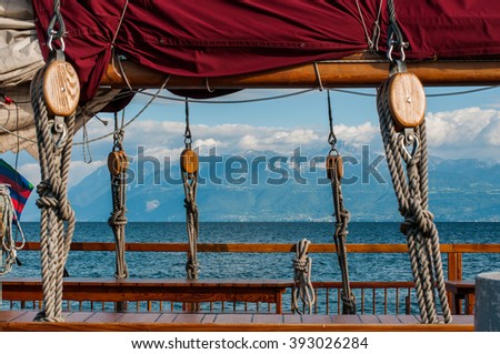 Mast of pirate ship with old sails tied rope isolated
