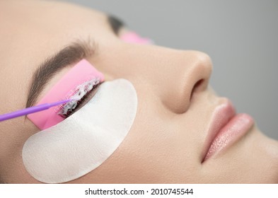 Master Applies Care Perm Cream To Eyelashes. Eyelash Care Treatment: Eyelash Lifting, Lash Lamination And Extension. Close-up Of Beauty Model's Face During Lash Lift Laminating Botox Procedure. 