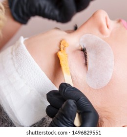 The Master Apply Scrub On Eyebrows With Wooden Stick For Prepare Them To Dyeing.