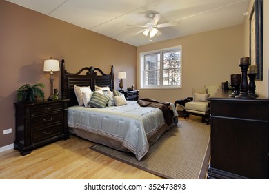 Master Bedroom In Condominium With Dark Wood Furniture