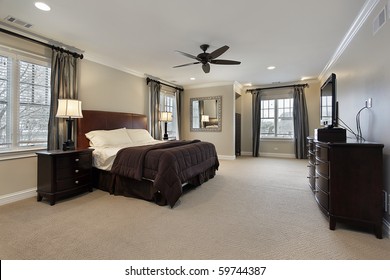 Master Bedroom In Luxury Home With Dark Wood Furniture