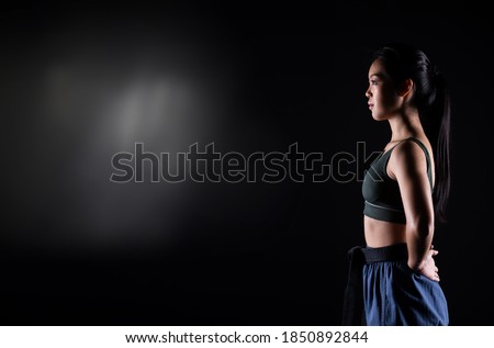 Master Black Belt TaeKwonDo Karate girl who is athlete young teenager show traditional Fighting poses in sport dress, black background isolated, low light exposure