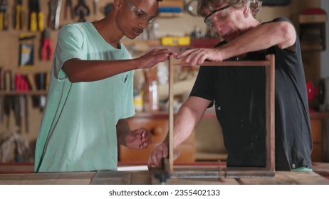 Master Carpenter Working with Apprentice at Carpentry Workshop, Senior Boss with Employee Engaged in Job Occupation