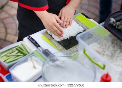 Master chef preparing delicious wedding sushi outdoors with a variety of ingredients
