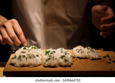 Master Chef Seasoning Of Fresh Water Eel With Parsley. High Quality Good Lighting Of Chef Seasoning.