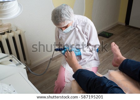 Master chiropody removes calluses . Hardware manicure.