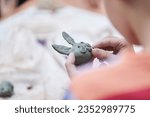 A master class for children on making toys from clay. A boy sculpts a figurine of an animal. Selective close-up focus with copy space. High quality photo