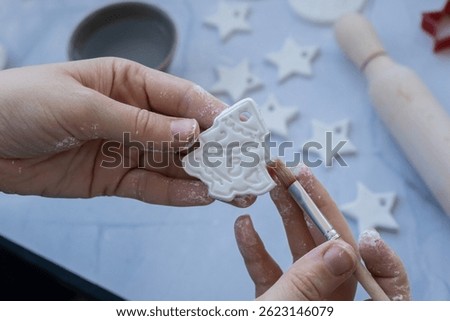 Master class of painting Creator is using white air dry clay for making decor to Christmas tree holiday. Creating hobby recreation activity that involves fingers. DIY crafting