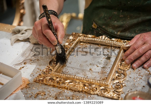 \
Master\
craftsman during the gilding process\
tecnique.\
