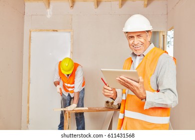 Master Craftsman With Tablet At Construction Site 