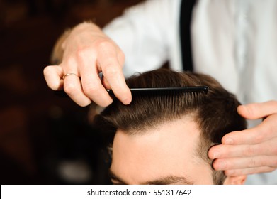 Master Cuts Hair And Beard Of Men In The Barbershop, Hairdresser Makes Hairstyle For A Young Man