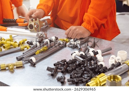 Master demonstrates components for installation of cross-linked polyethylene water pipes. Industry