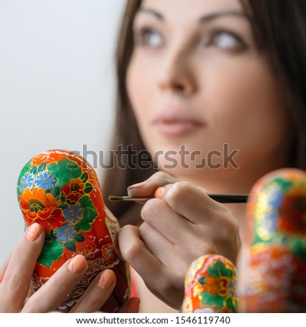 Master drawing patterns on matrioshka in studio