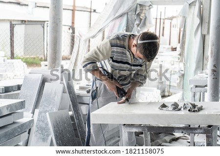 The master engraves the tombstone. Stone processing