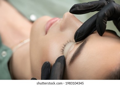 Master fits white curl for lashes. Eyelash Care Treatment: lifting and curling, lash lamination and extension for lashes.  Close-up of beauty model's face during lash lift laminating botox procedure.