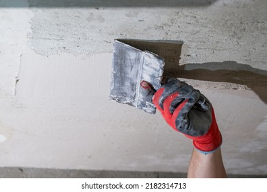 The Master In Gloves Aligns The Ceiling With Lime Plaster Close Up.