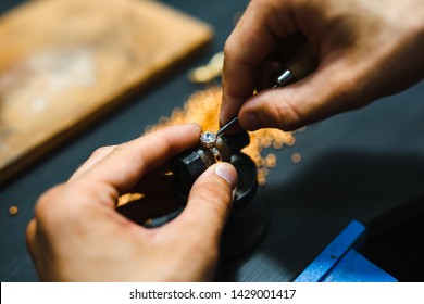 Master goldsmith while working on jewelry on the of work table.