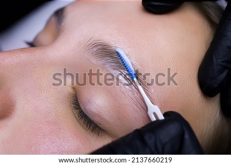 the master has a comb for laminating eyebrows in the palm of his hand