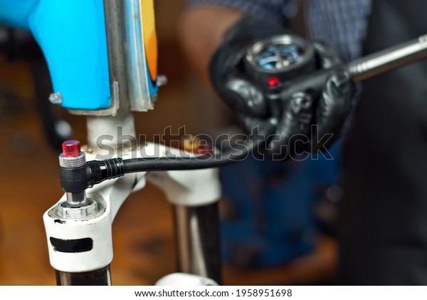 The master inflated the bicycle frame. Pump and male\
hands close up.